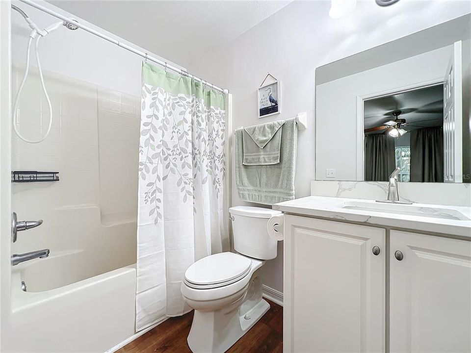 Guest bathroom has been updated with a high counter and quartz countertop, new sink, faucet and toilet