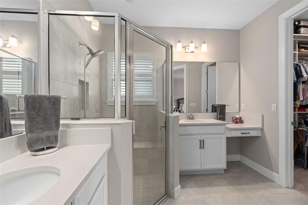 he Primary Bathroom showing the Split Comfort Height Vanities, Separate Shower with a Seat and a Walk-In Closet with Organizers.