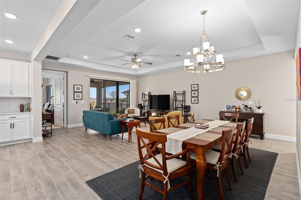 View from the Dining Area toward the Family Room and Lanai. This home also offers 8' Interior Doors adding to the Grand Appearance.