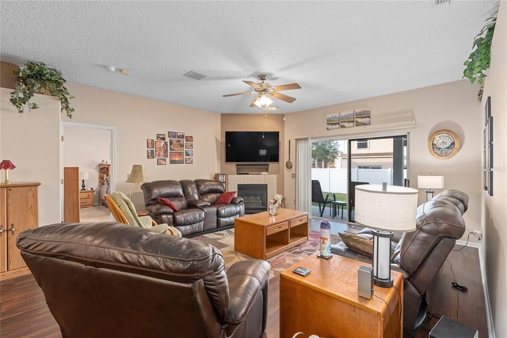 GREAT ROOM WITH ELECTRIC FIREPLACE AND LUXURY VINYL PLANK FLOORING.