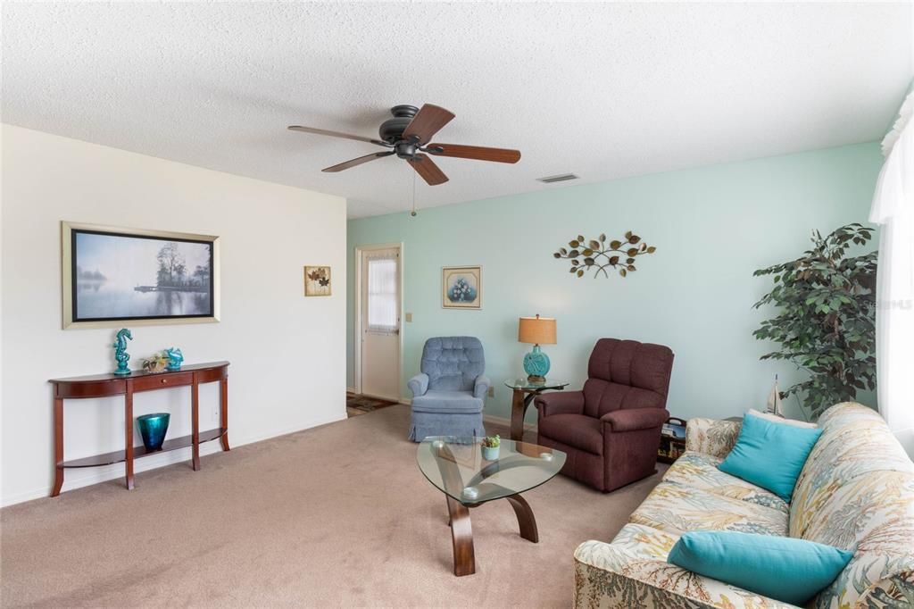 Living Room features a Ceiling Fan & Wall to Wall Carpeting