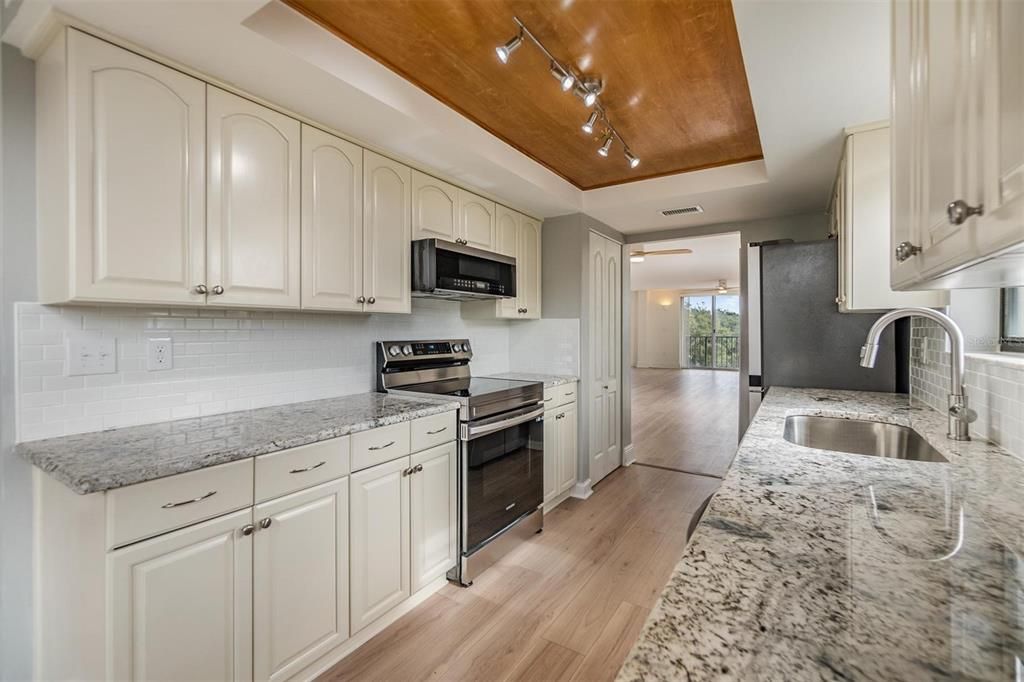 Remodeled galley-style kitchen with beautiful granite countertops, new stainless steel appliances, plenty of cabinet space, pantry, and a breakfast nook.