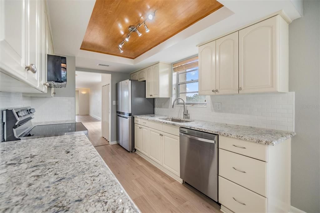 Remodeled galley-style kitchen with beautiful granite countertops, new stainless steel appliances, plenty of cabinet space, pantry, and a breakfast nook.