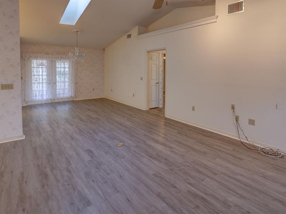 Family room and dining room leading out to the attached sunroom. Vaulted ceilings.