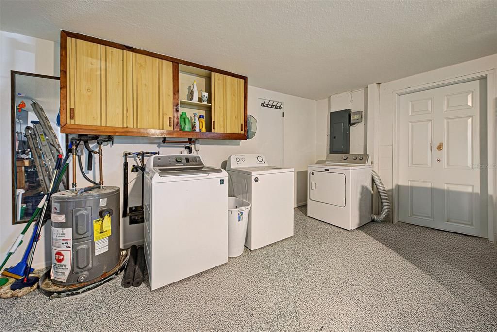 The washer and dryer are conveniently located in the garage with cabinets.