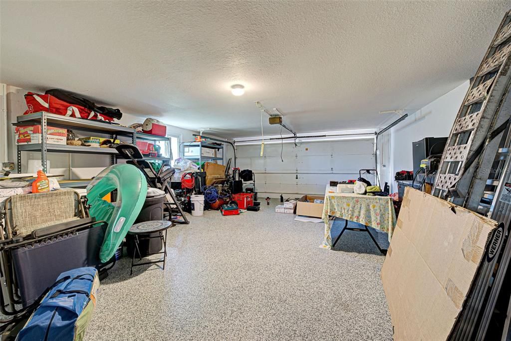 An extra large garage with garage door opener and epoxy flooring.