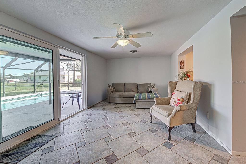 Beautiful sliding glass doors open the Florida Room up to the lanai and caged pool.