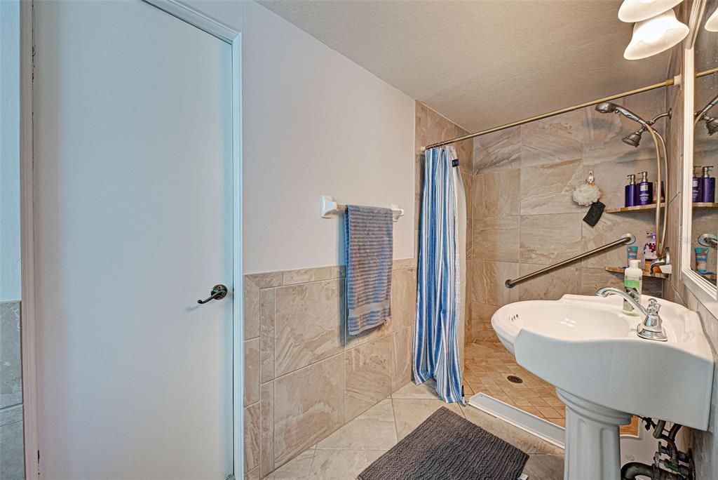 The second bathroom has a pedestal sink and large walk-in shower.