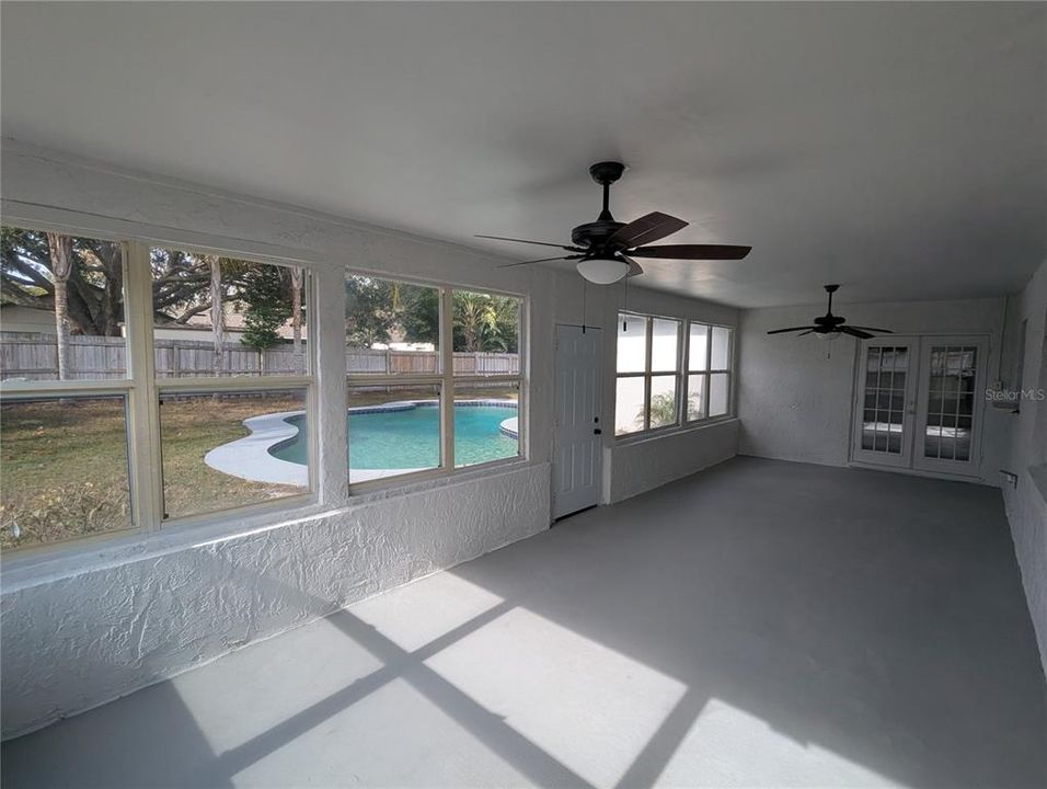 Rear porch overlooking large open pool and private fenced rear yard