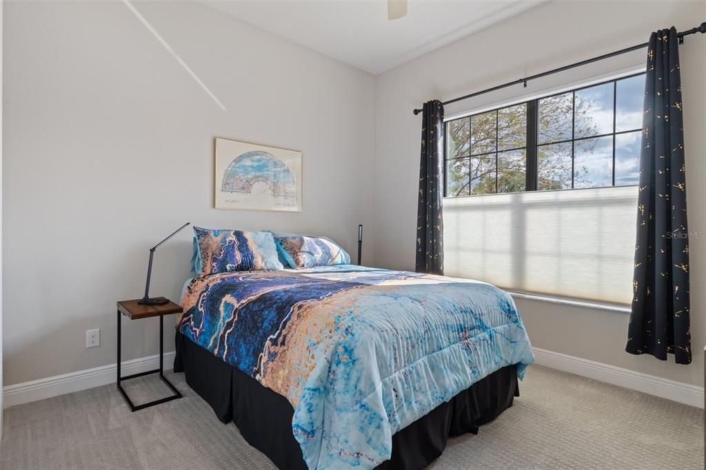 The guest bedroom provides room for a queen bed and nightstands, while leaving room for other furniture on the opposite wall.