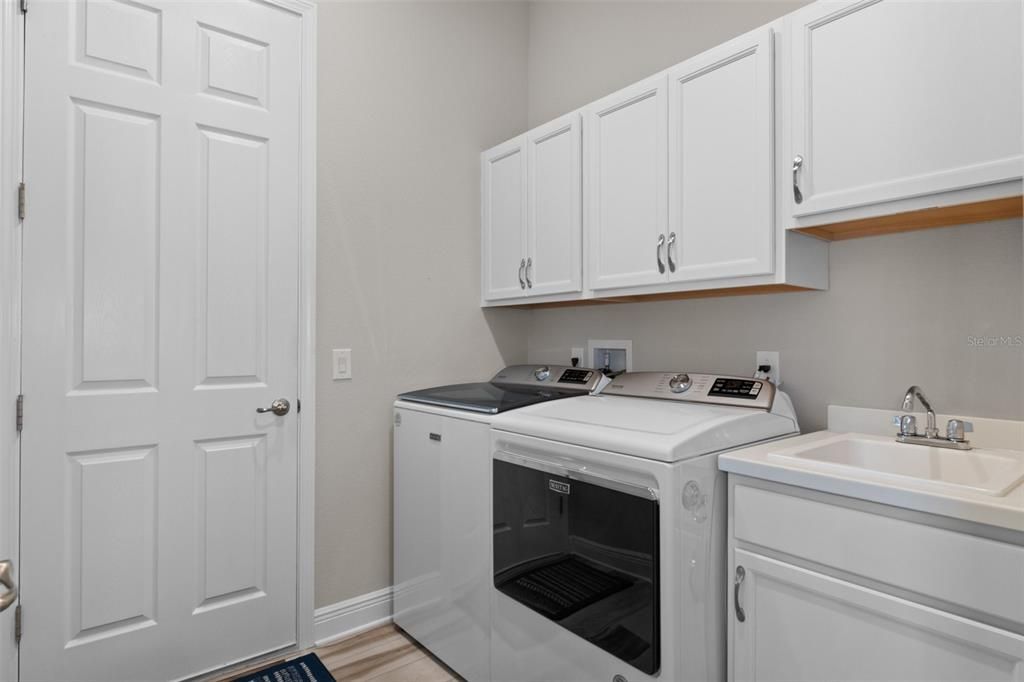 The indoor laundry room is a great feature, complete with a deep utility sink and more storage. The door leads to the 2 car garage.