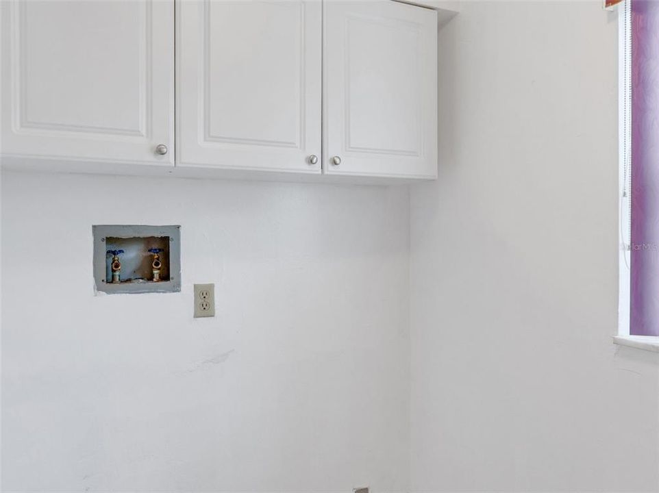 Private laundry room with upgraded white cabinets