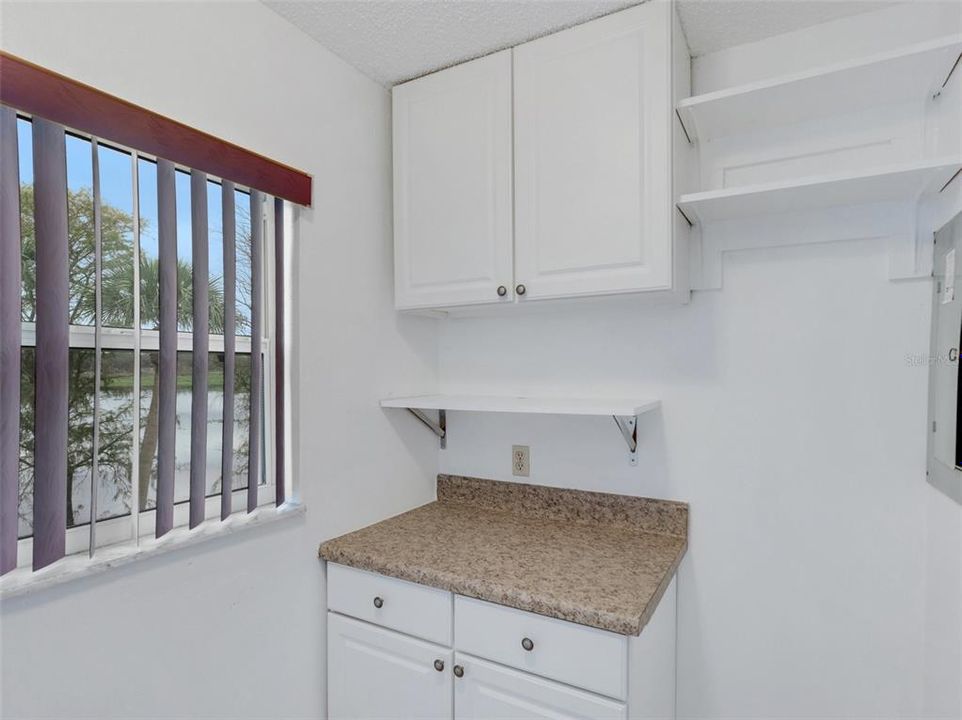 Private laundry room with upgraded white cabinets, granite counters, and extra storage