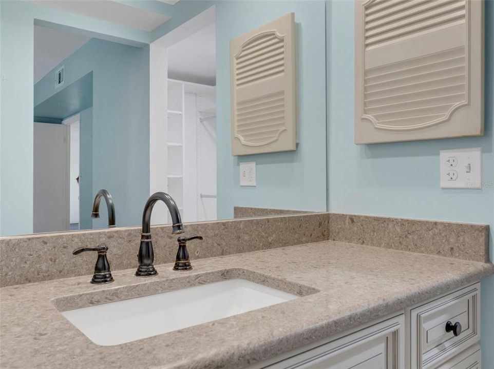 Primary bathroom with upgraded cabinets, granite counters, and faucets