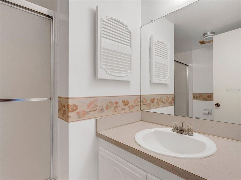 Second bathroom with tub shower and glass doors