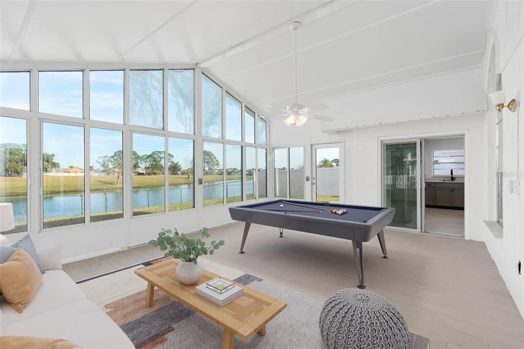 Enclosed porch overlooks a tranquil lake, perfect for relaxing or entertaining.