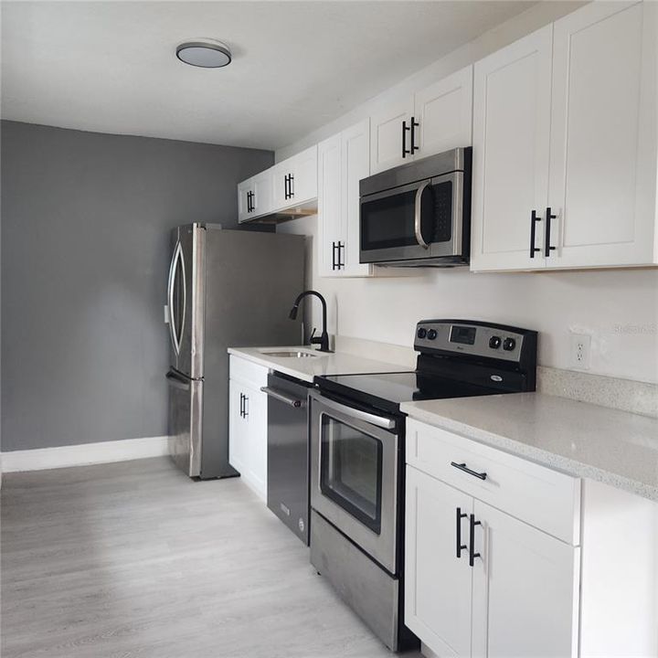 Brand new kitchen with new shaker style cabinets, new quartz counters, new stainless steel appliances, and new fixtures and hardware.