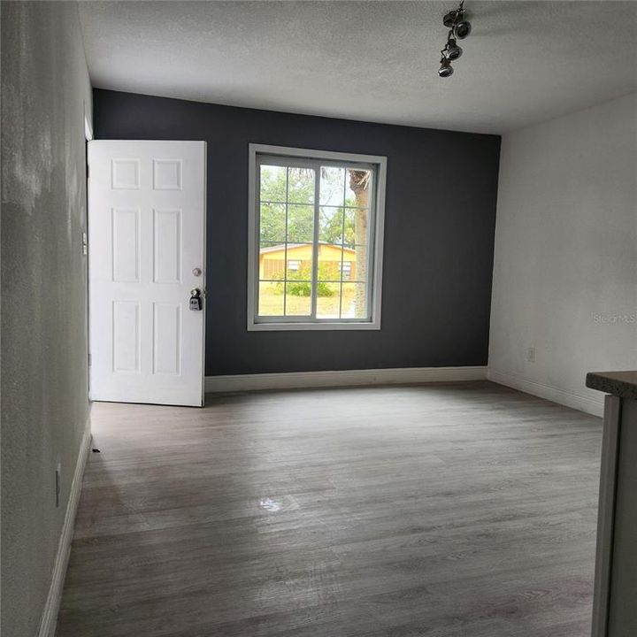 Roomy living room with a new window and sideboard for dining area.