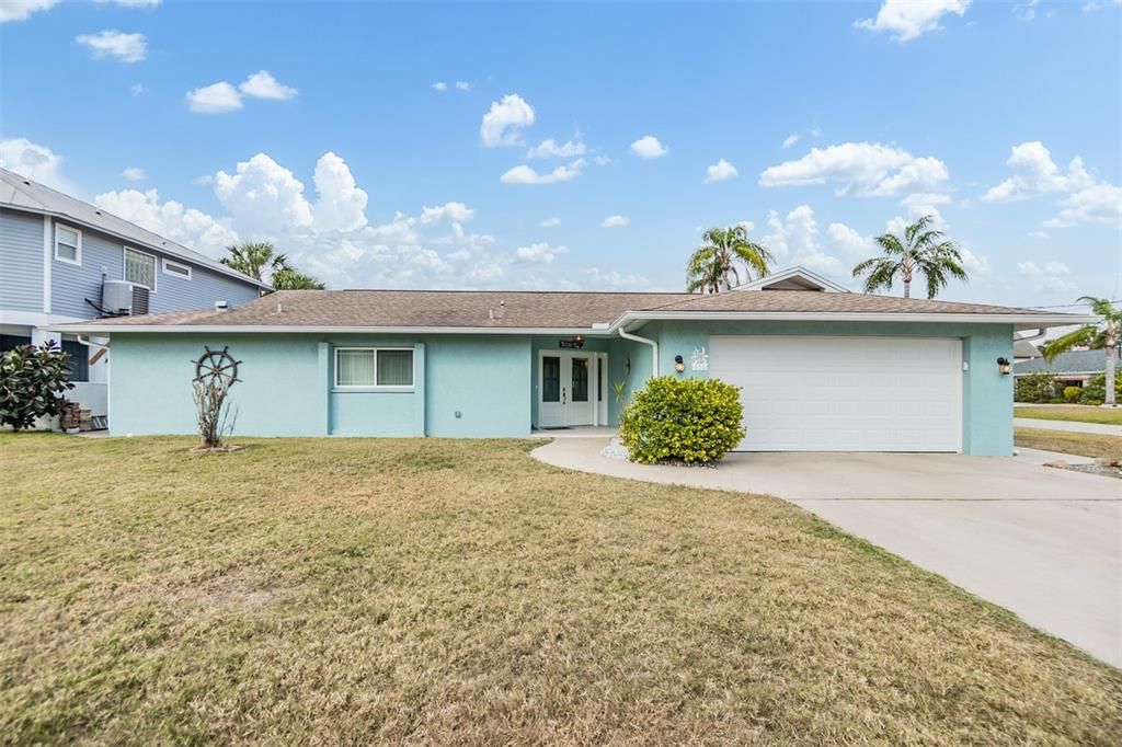 Welcome to this charming coastal-style home, boasting fantastic curb appeal with its soft blue exterior and manicured landscaping. The spacious driveway offers ample parking, while the lush palms and bright skies create the perfect Floridian vibe. This property is ready to welcome you home!