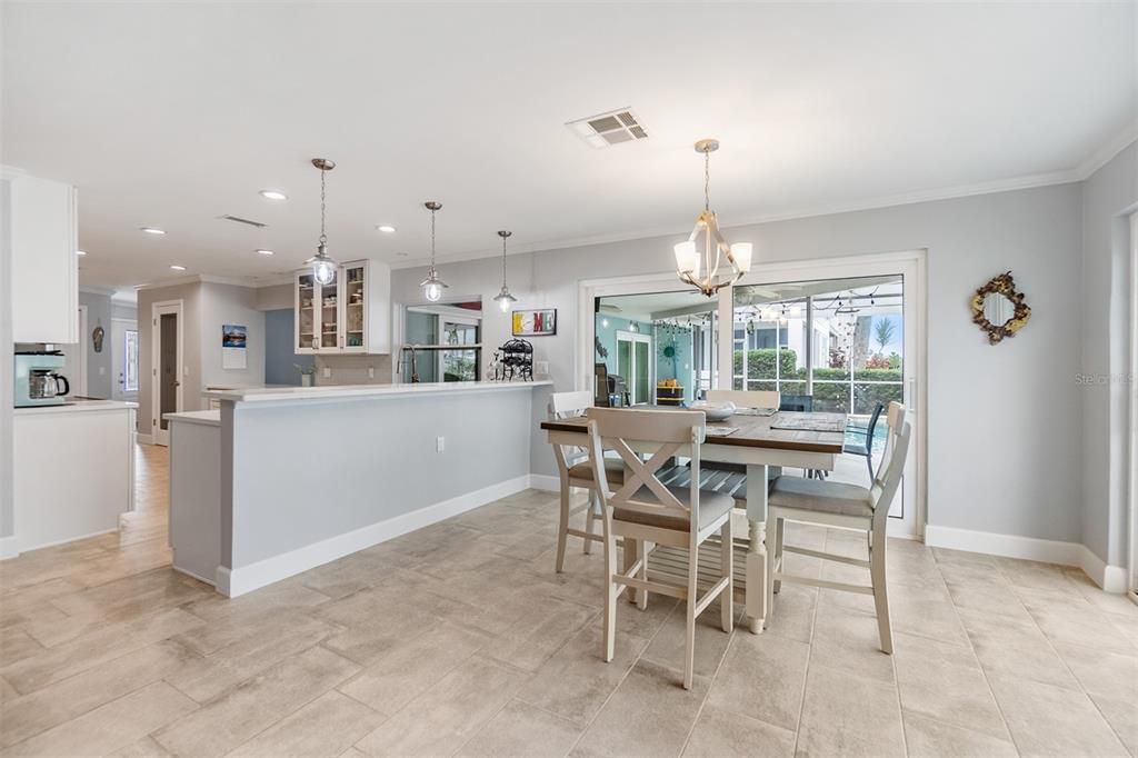 This bright and airy dining space offers a seamless flow between the kitchen and living areas, perfect for hosting gatherings or enjoying family meals. Filled with natural light and provides beautiful views of the outdoor surroundings. The neutral tile flooring and contemporary design complete the inviting ambiance.