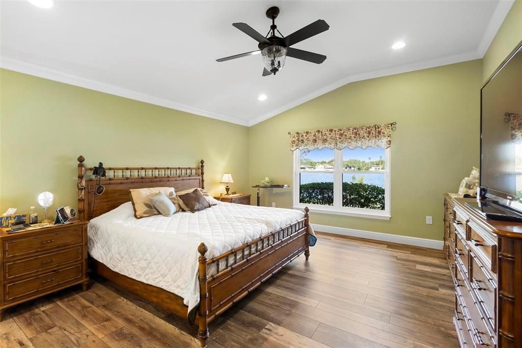 Primary bedroom suite with cathedral ceilings and recessed lighting.