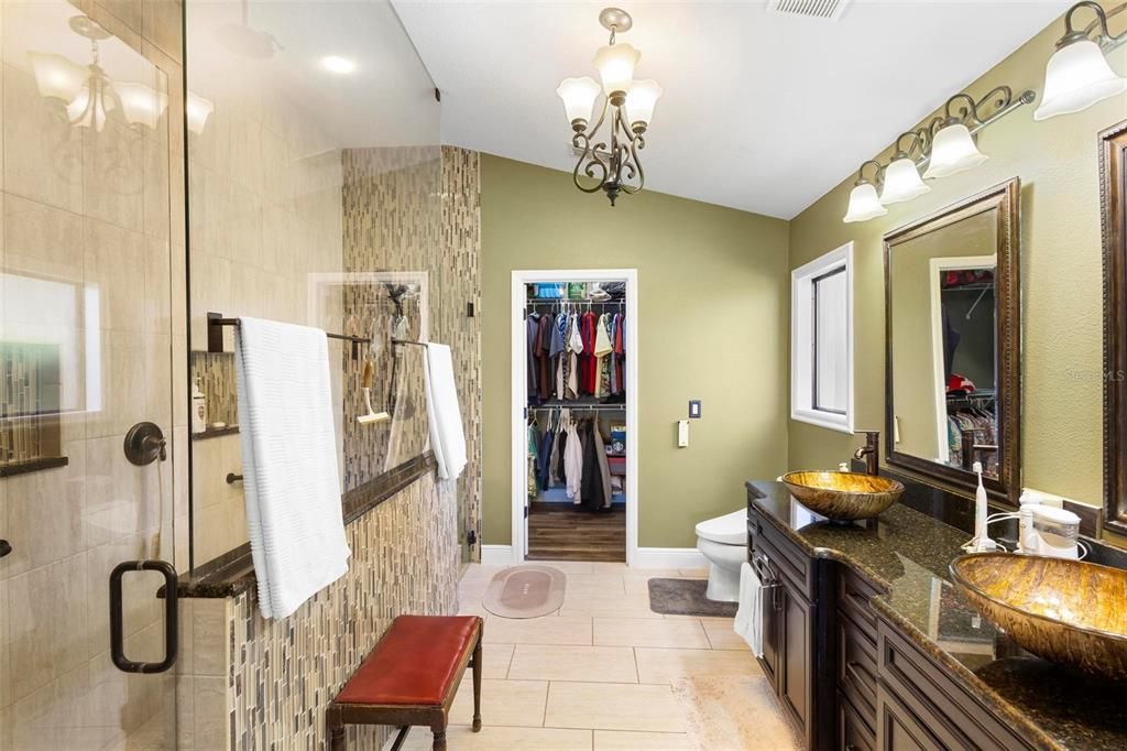 Ensuite bath. Huge walk-in with three showerheads at left. Walk-in closet afar.