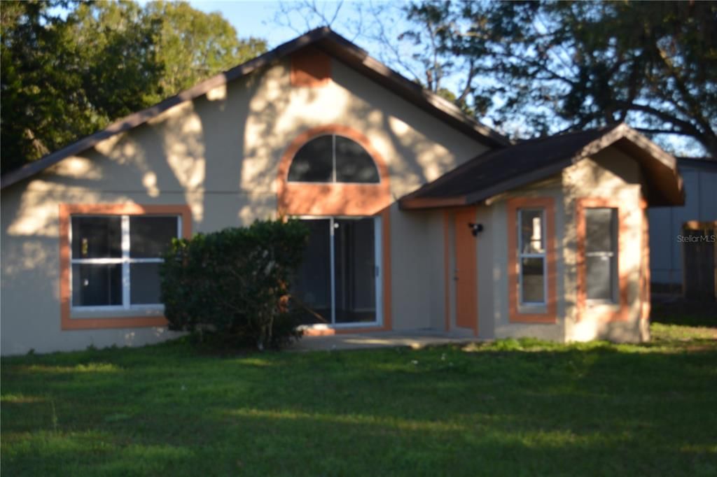 Back of the house with view of the door leading into the kitchen and slider doors leading into the living area