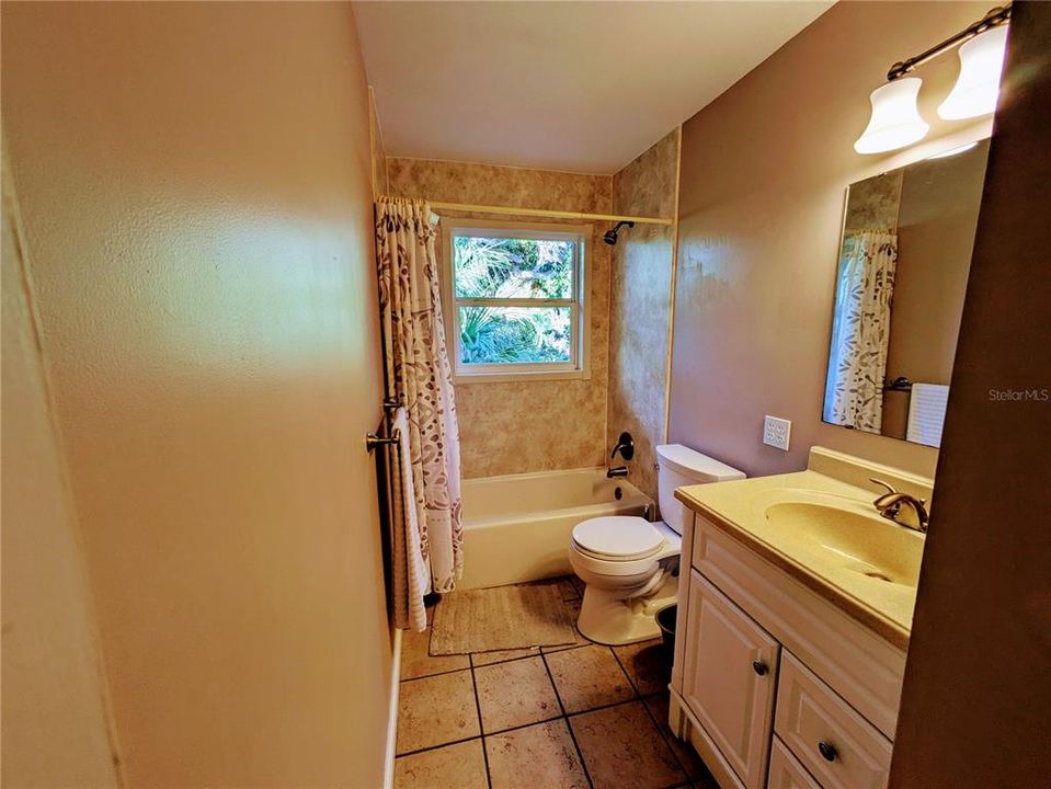 The guest bathroom with a tub shower and new vanity.