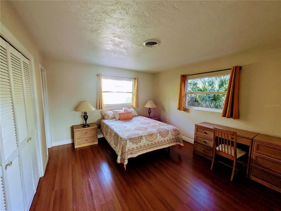 The primary bedroom with large windows plus sliders to the lanai