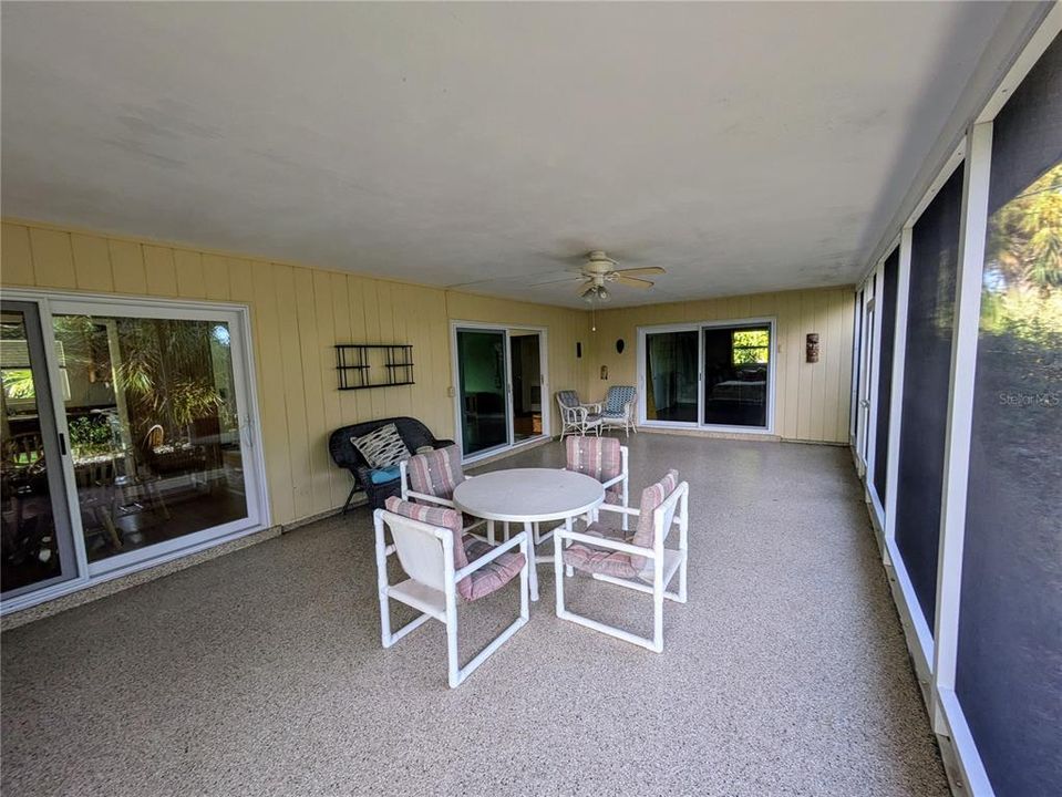 The huge, 30' wide lanai, covered and screened for all-season enjoyment. There are sliders from the dining room, lthe iving room and the primary bedroom. There are no neighbors behind this home for lots of privacy.