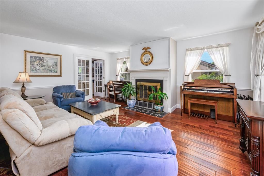 Living room with engineered hardwood wood flooring and wood burning fireplace.