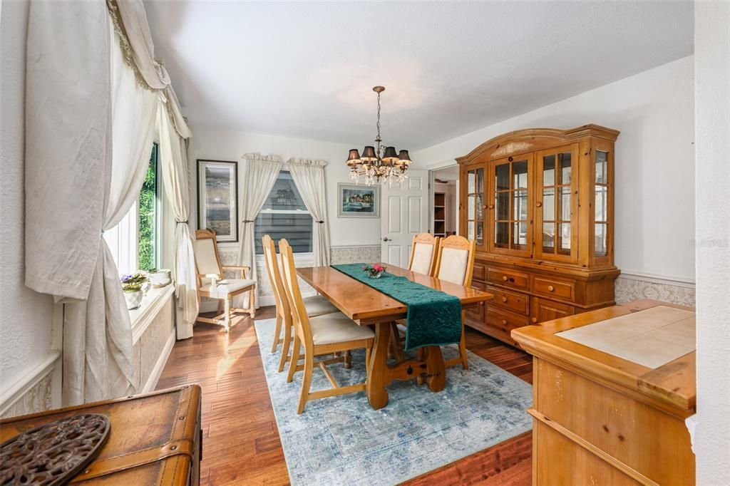 Dining room with wood flooring and bay window.