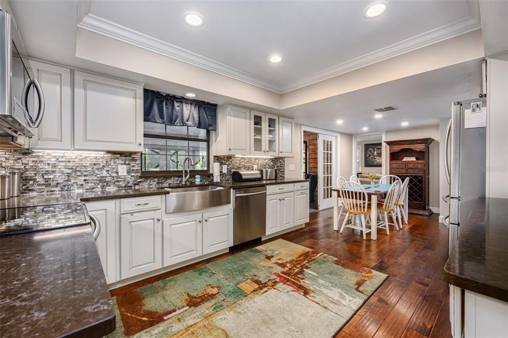 Kitchen recently renovated with quartz counter tops, backsplash, S/S appliances, farm house sink, try ceiling with crown molding and engineered hardwood flooring.