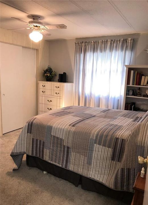 Secondary bedroom with large window and closet