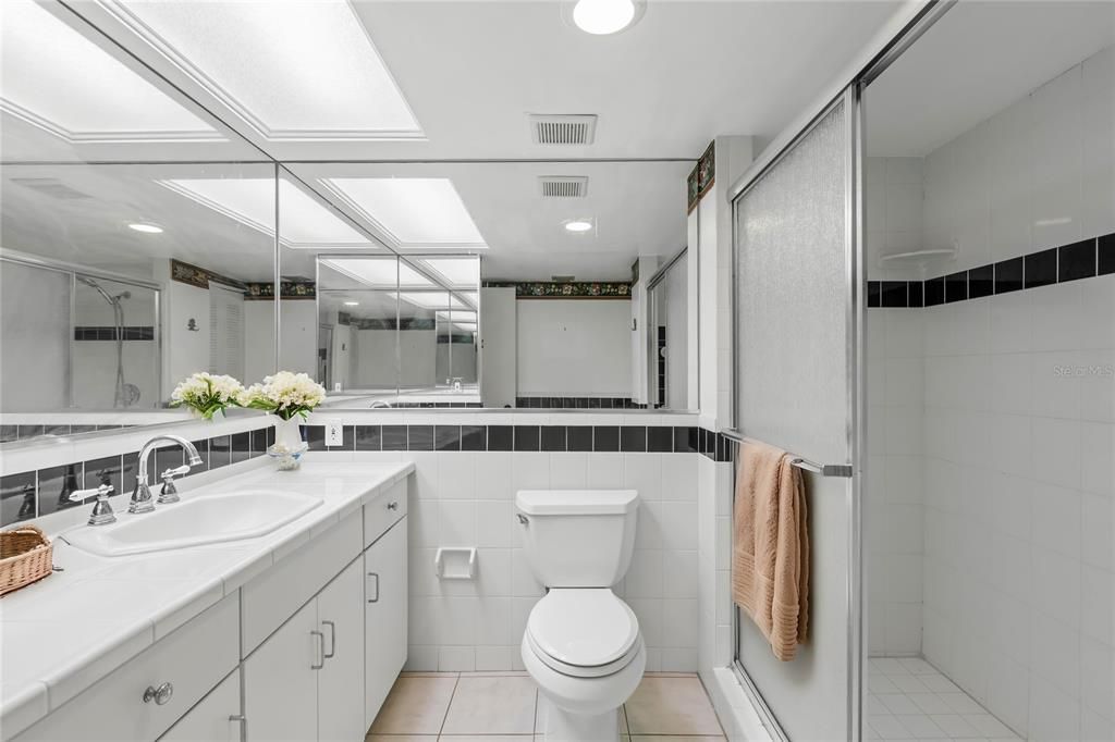 Full guest bathroom with step-in shower and linen closet. Virtual staging