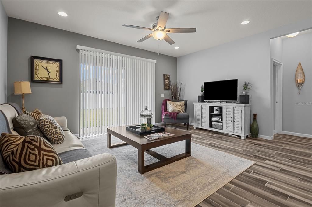 Living room with slider access to the fenced in backyard - door on right leads to primary suite