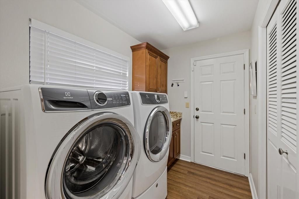 Separate laundry room off kitchen with large pantry, sink, storage and direct entry to garage.