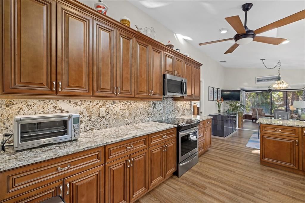 Tastefully updated kitchen with quality cabinetry, stainless appliances granite counters and backsplash, soft-close drawers.