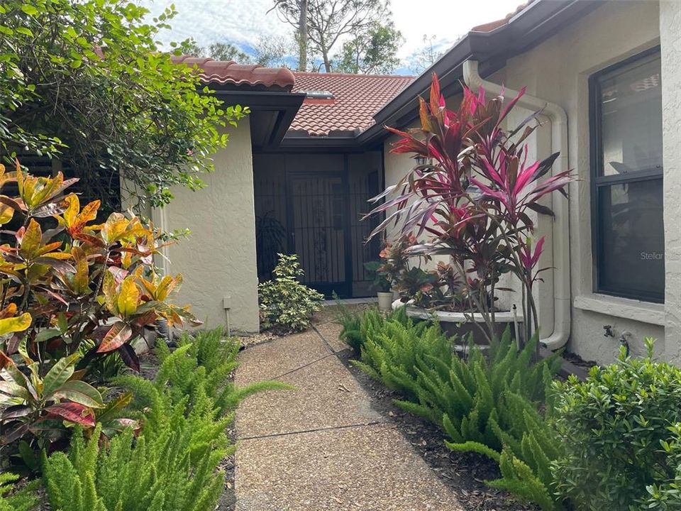 Private front entry with mature landscaping.