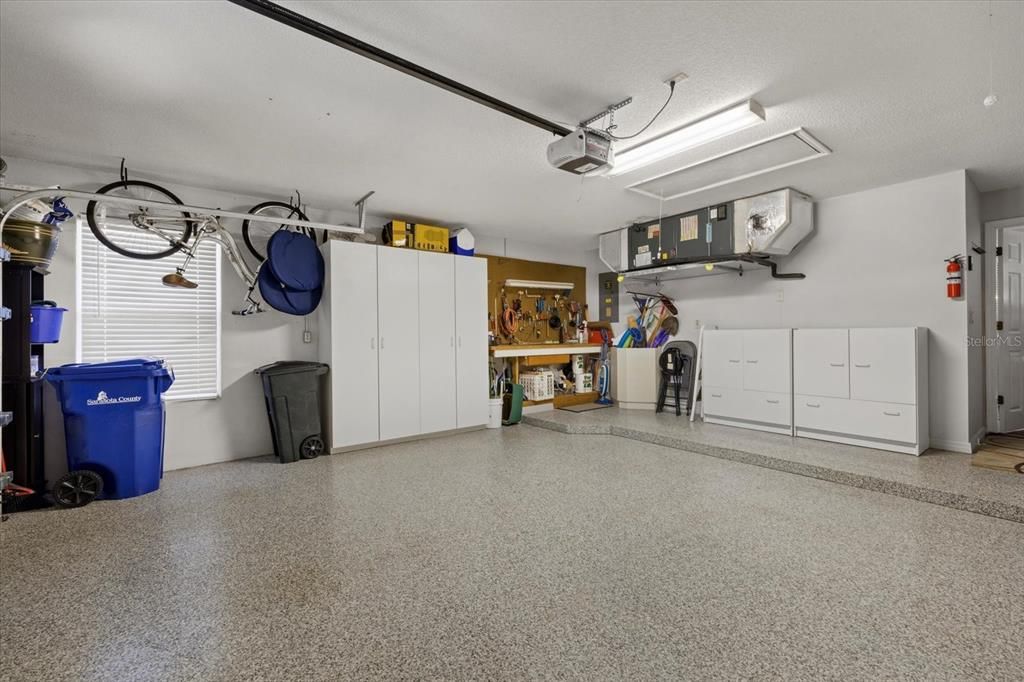 Spacious and clean two-car garage with epoxy floor. Cabinetry conveys with the property.