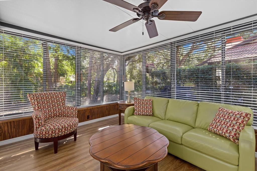 Sunroom off the living room offers a peaceful greenbelt view.