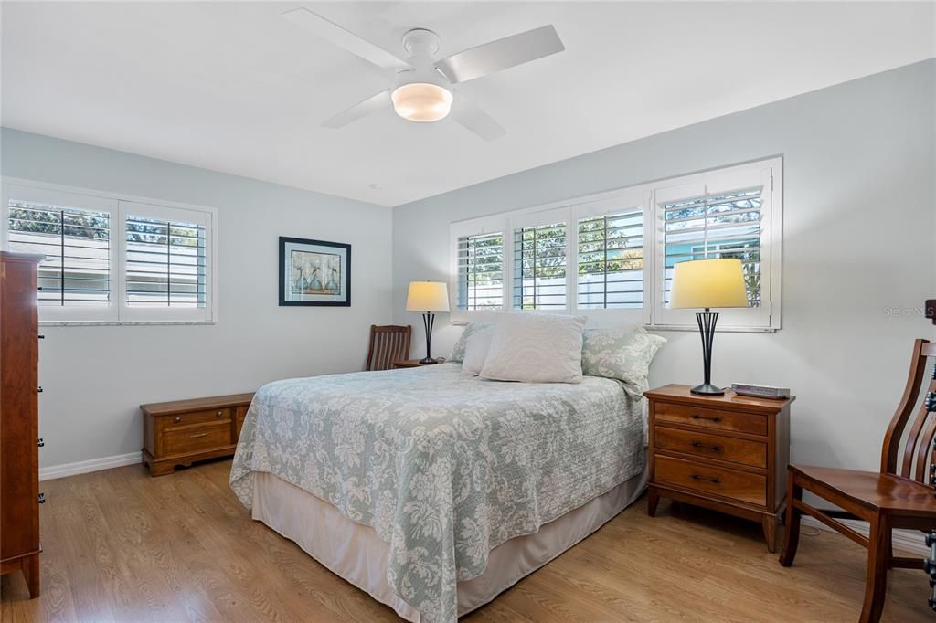 Primary Bedroom is spacious and has two large windows adorned with Plantation Shutters for easy control of the natural light in the room