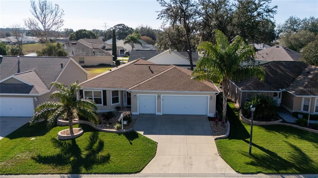 Charming curb appeal with mature palm trees and hardscaping.