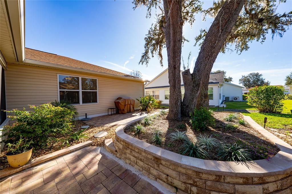 The two outdoor patios provides more seating and grill areas. The hardscaping and mature tree adds to the beauty of this property!