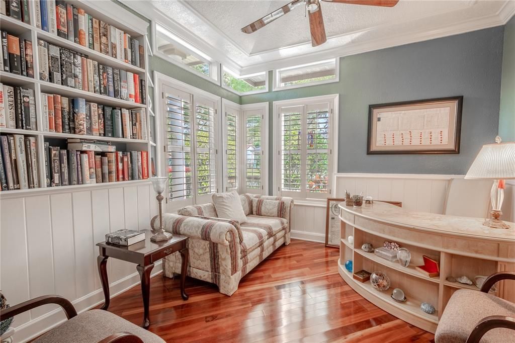 Bedroom 2, currently used as the home office has a stunning Brazilian Koa floor, corner windows, crown molding, a built-in closet and a built in bookshelf.