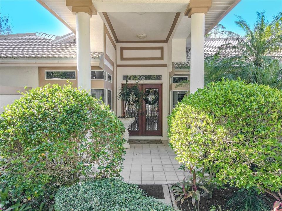 Show stopping, covered entry with 8' Tall, Brazilian Mahogany Doors with beveled Glass.