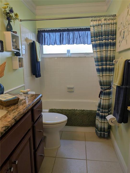 Main bath updates include commode, tile flooring, wood vanity w/granite countertop, light fixtures, plumbing fixtures and mirror. This bath offers option of soothing bath or quick shower.