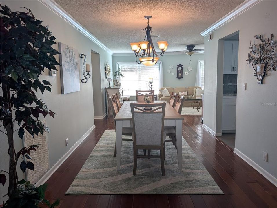 Dining room view of kitchen to right, hallway to Primary suite/interior laundry to left and Florida room straight ahead.