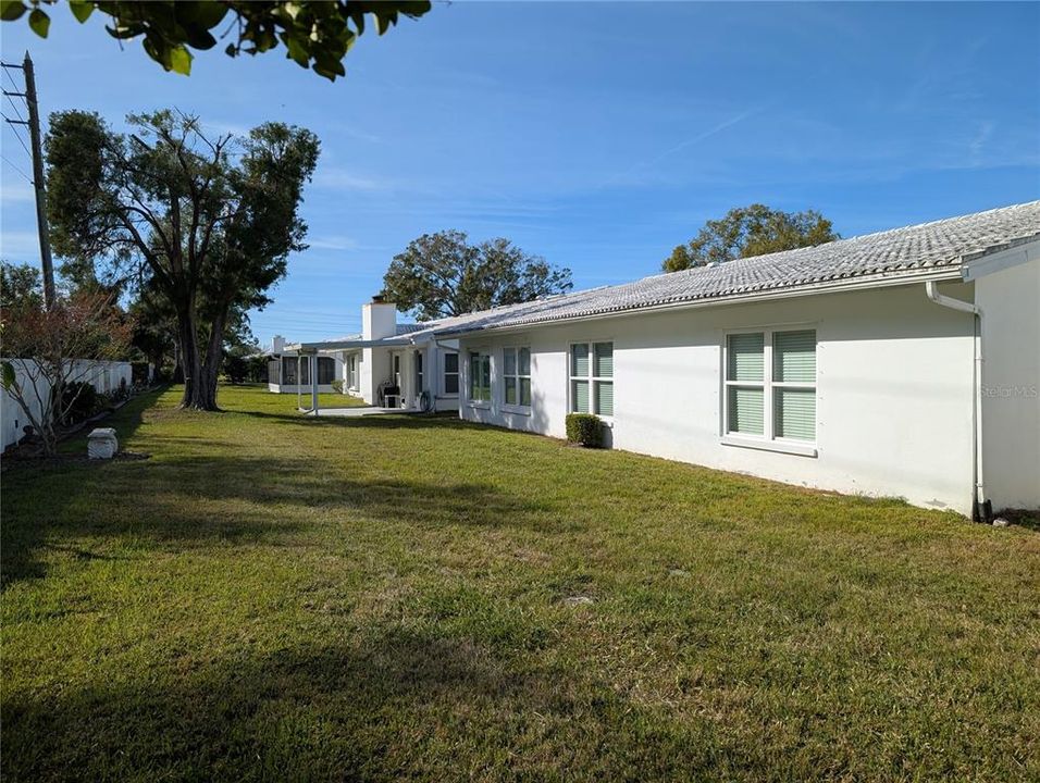 Exterior view of florida room, bonus room and primary bedroom. Private backyard.