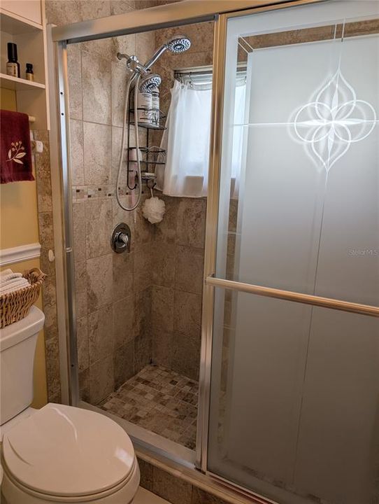 Updates included glass shower doors and plumbing fixtures.  Window in shower provides ventilation and natural ligh.